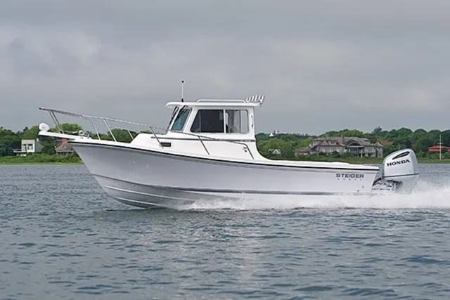 The Image of A Steiger Craft Miami 2027 boat speeds across the water, surrounded by green landscape. - 1