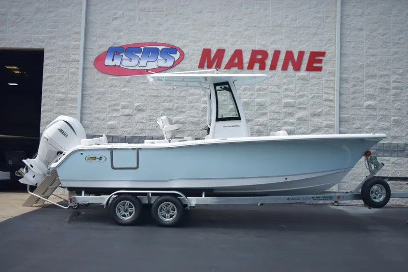 The Image of A 2025 Sea Hunt Ultra 239SE boat on a trailer in front of a marine store. - 1