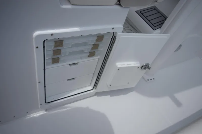 Slide: The Image of An open storage compartment with drawers on a boat, surrounded by white decking. - 17
