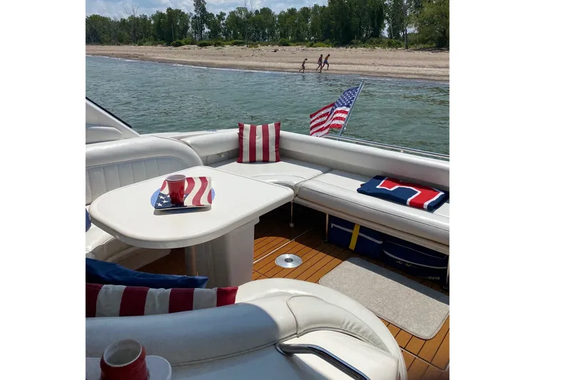 Slide: The Image of 1997 Sea Ray 450 Sundancer boat interior with American-themed decor by the shore. - 8