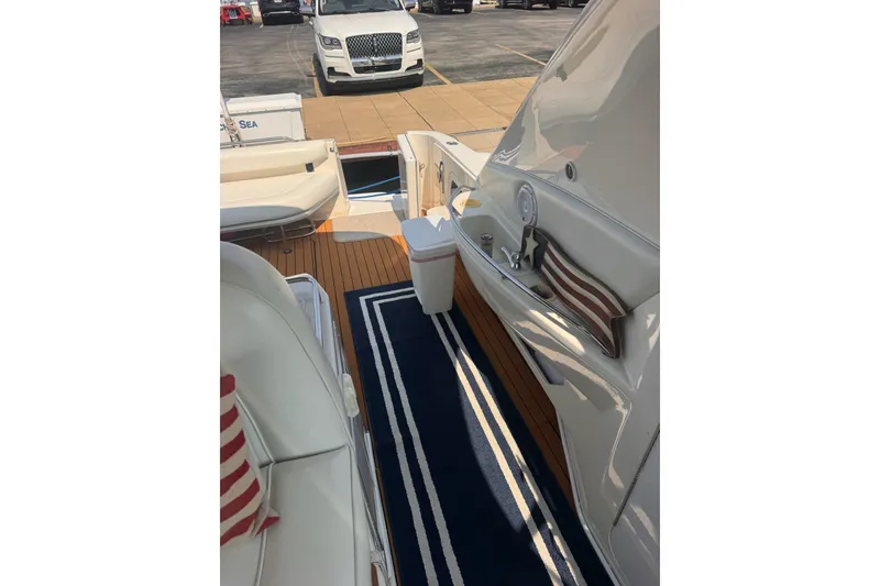 Slide: The Image of 1997 Sea Ray 450 Sundancer yacht interior with striped cushions and wooden deck. - 13