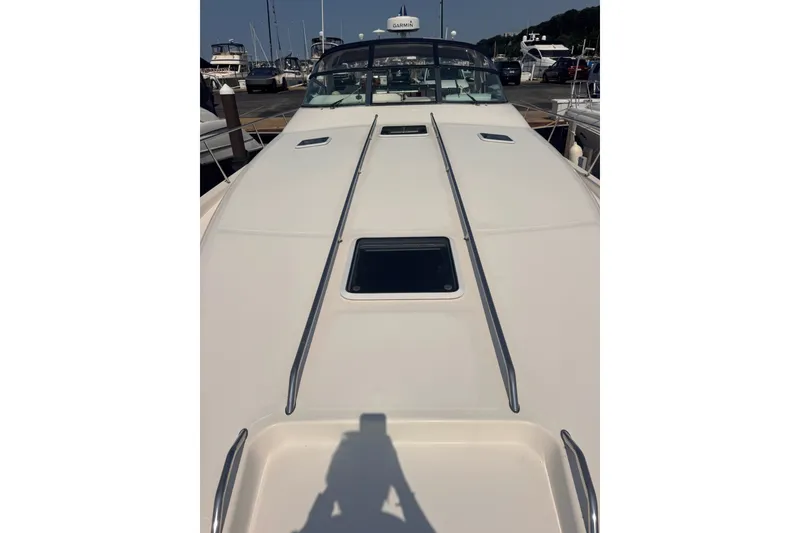 Slide: The Image of 1997 Sea Ray 450 Sundancer yacht docked, showcasing sleek deck design and marina background. - 6