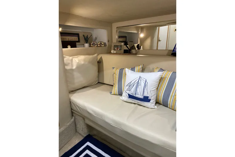 Slide: The Image of Cozy interior of 1997 Sea Ray 450 Sundancer with nautical-themed pillows and decor. - 30