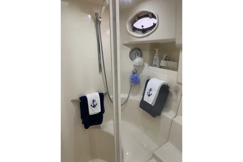 Slide: The Image of Shower area in 1997 Sea Ray 450 Sundancer yacht with nautical-themed towels. - 36