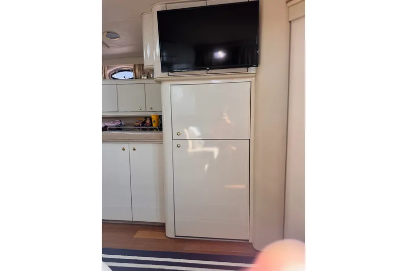 Slide: The Image of Interior of 1997 Sea Ray 450 Sundancer with TV and storage cabinets. - 32