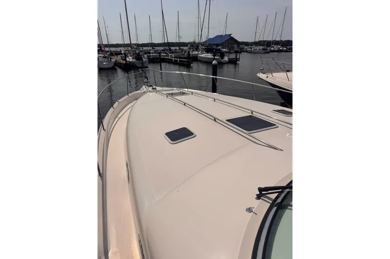 Slide: The Image of 1997 Sea Ray 450 Sundancer yacht docked at a marina with sailboats in the background. - 5