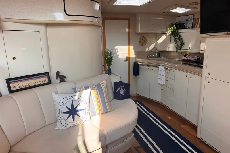 Slide: The Image of Interior of a 1997 Sea Ray 450 Sundancer yacht with cozy seating and kitchenette. - 26