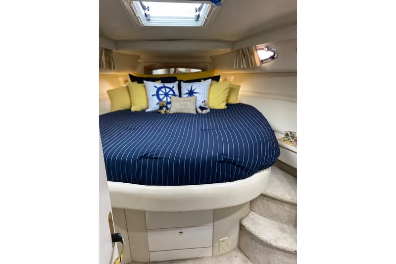 Slide: The Image of Luxurious 1997 Sea Ray 450 Sundancer cabin with nautical-themed bedding and cozy interior. - 35