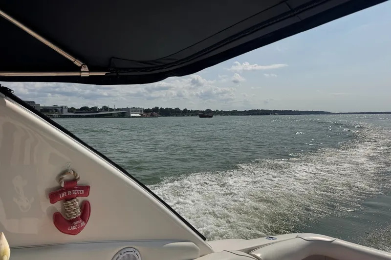 Slide: The Image of 1997 Sea Ray 450 Sundancer cruising on a sunny lake with scenic shoreline views. - 7