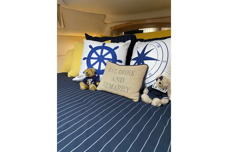 Slide: The Image of Cozy cabin interior of 1997 Sea Ray 450 Sundancer with nautical-themed pillows and teddy bears. - 34