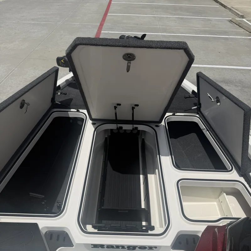 Slide: The Image of The image shows the open storage compartments of a 2019 Ranger Z518 boat. - 26