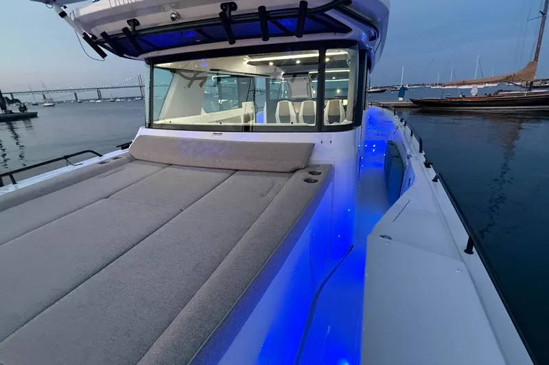 Slide: The Image of 2024 Axopar 45 XC Cross Cabin boat with illuminated deck at sunset in marina. - 9