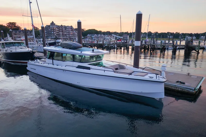 Slide: The Image of 2024 Axopar 45 XC Cross Cabin docked at sunset in a scenic marina. - 43