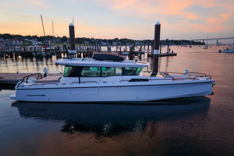 Slide: The Image of 2024 Axopar 45 XC Cross Cabin boat docked at sunset, showcasing sleek design. - 1