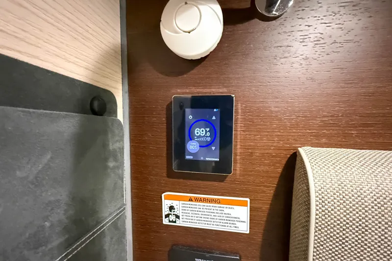Slide: The Image of 2024 Axopar 45 XC Cross Cabin interior with digital thermostat and warning label. - 42