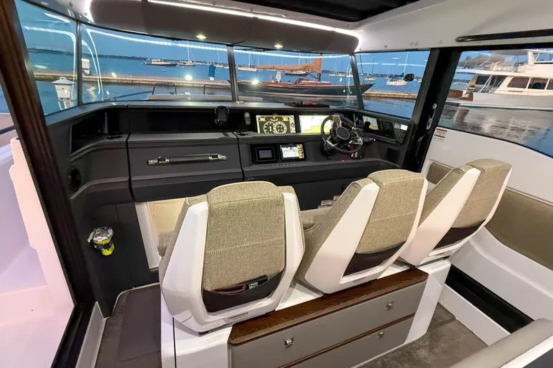 Slide: The Image of 2024 Axopar 45 XC Cross Cabin interior with modern dashboard and seating, docked at marina. - 29