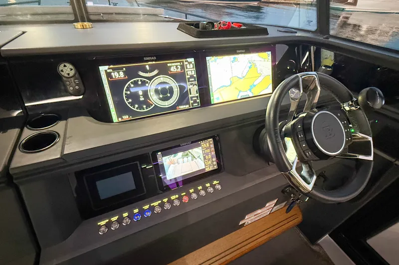 Slide: The Image of 2024 Axopar 45 XC Cross Cabin dashboard with advanced navigation displays and steering wheel. - 32