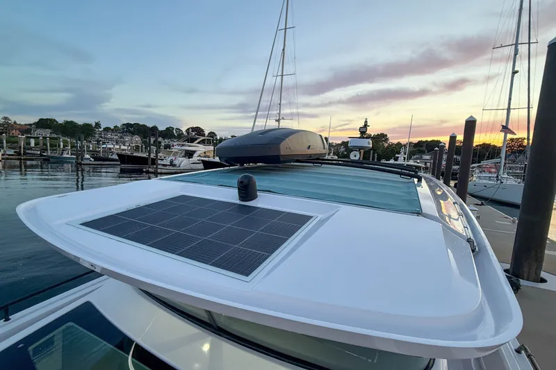 Slide: The Image of 2024 Axopar 45 XC Cross Cabin with solar panel at marina during sunset. - 12