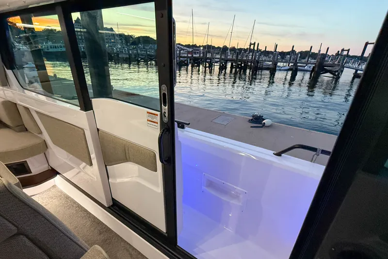 Slide: The Image of 2024 Axopar 45 XC Cross Cabin interior with marina view at sunset. - 16