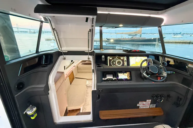 Slide: The Image of 2024 Axopar 45 XC Cross Cabin interior with navigation controls and cozy seating area. - 34