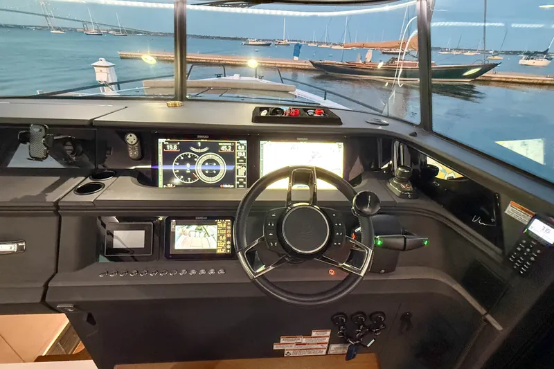 Slide: The Image of 2024 Axopar 45 XC Cross Cabin helm with advanced navigation displays and waterfront view. - 30