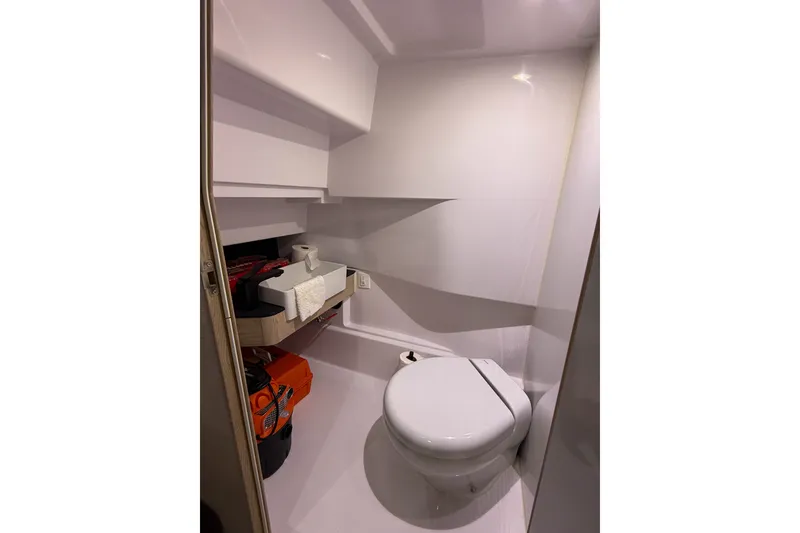 Slide: The Image of 2024 Axopar 45 XC Cross Cabin bathroom with modern white fixtures and storage shelves. - 40