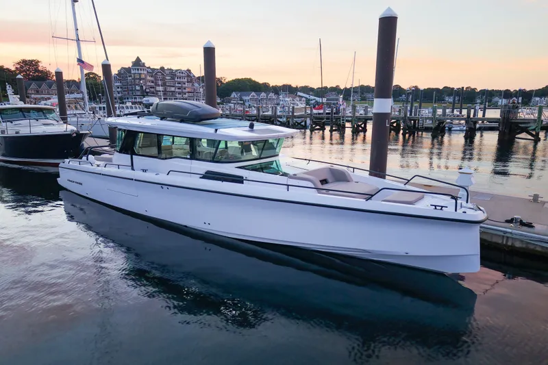 The Image of 2024 Axopar 45 XC Cross Cabin docked at a marina during sunset. - 0