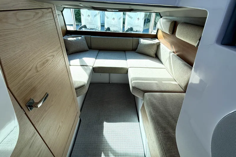 Slide: The Image of 2024 Axopar 45 XC Cross Cabin interior with cozy seating and wooden accents. - 23
