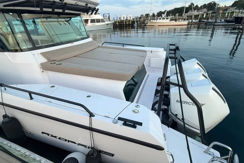 Slide: The Image of 2024 Axopar 45 XC Cross Cabin with Mercury engines docked at a marina. - 6