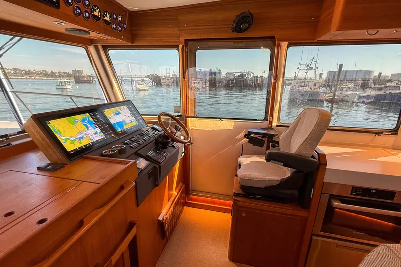 Slide: The Image of Interior of 2026 Targa 41 boat with navigation screens and captain's chair, overlooking marina. - 30