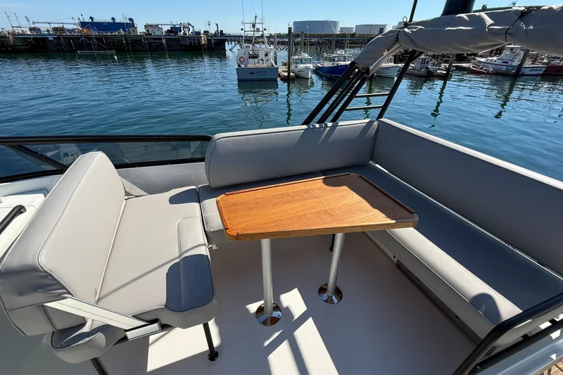 Slide: The Image of Luxury seating area on 2026 Targa 41 boat, featuring a wooden table and waterfront view. - 13