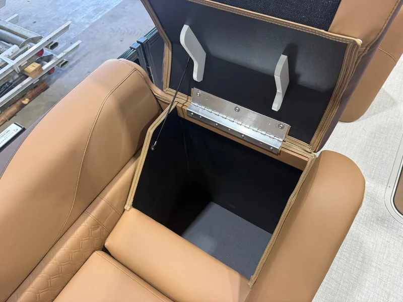 Slide: The Image of An open storage compartment in a boat with brown upholstery and metal handles. - 28