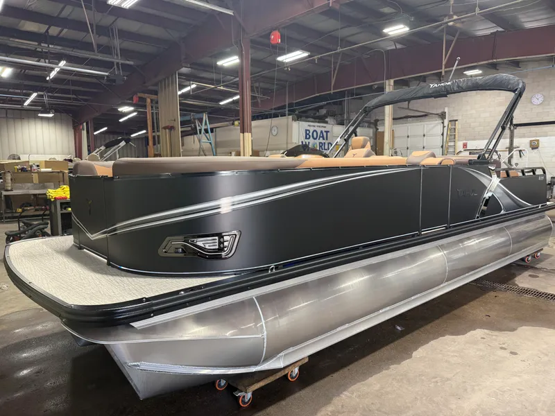 Slide: The Image of A modern tritoon with a black hull and silver accents in a warehouse setting. - 40