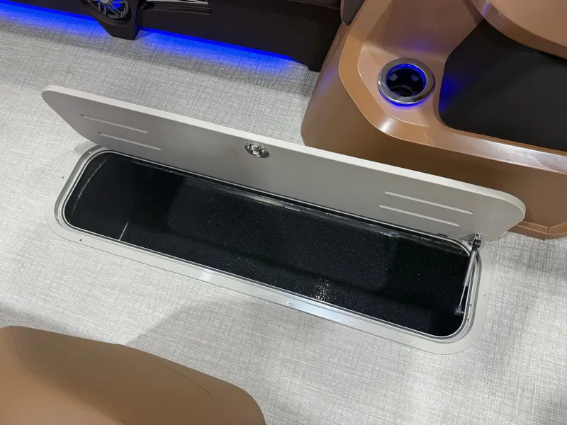 Slide: The Image of An open storage compartment on a boat with brown seating and blue lighting. - 32