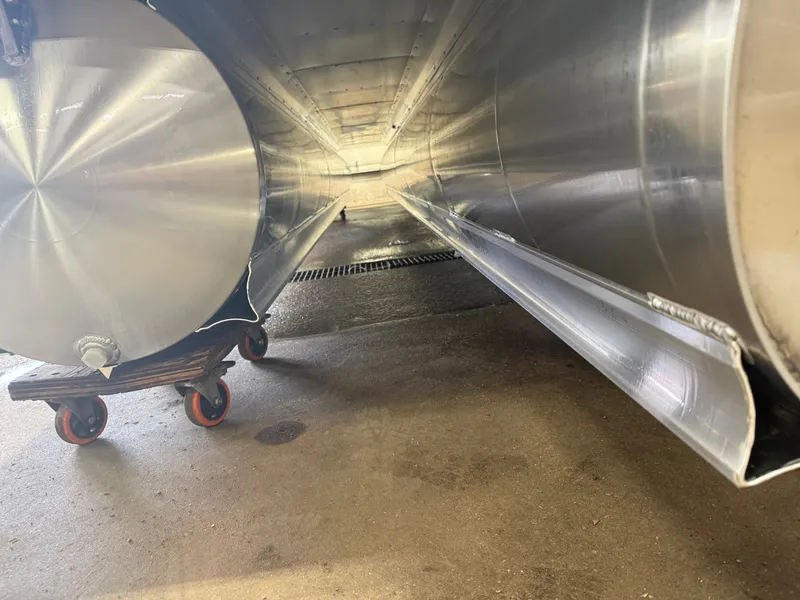 Slide: The Image of Close-up of the underside of a tritoon boat with aluminum hulls on a rolling cart. - 45