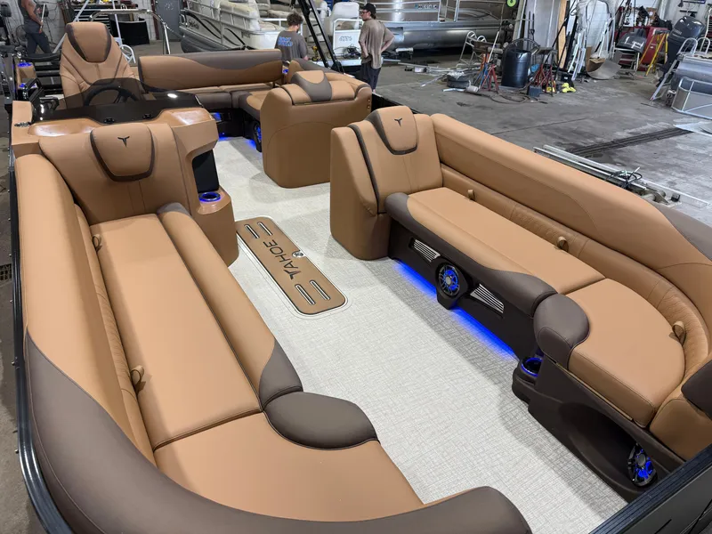 Slide: The Image of Luxurious interior of a Tahoe LTZ 300HP VRB 2385 Swingback Tritoon with beige leather seating and blue lighting. - 36