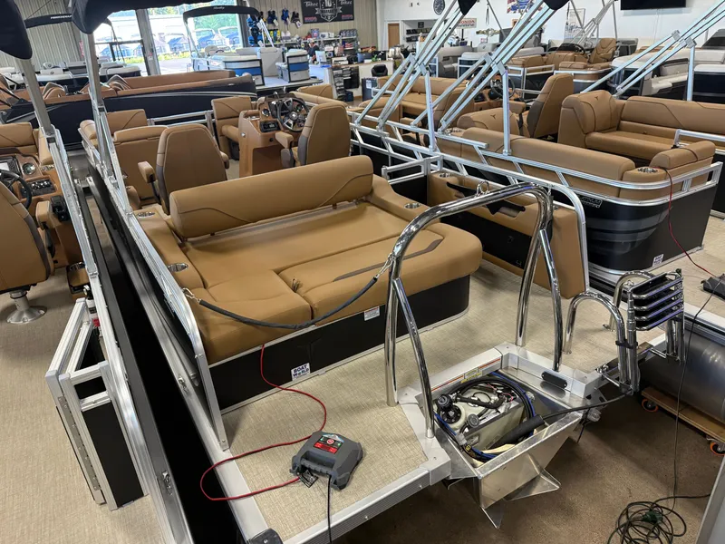 Slide: The Image of A modern pontoon boat interior with beige seating and stainless steel railings in a showroom. - 37