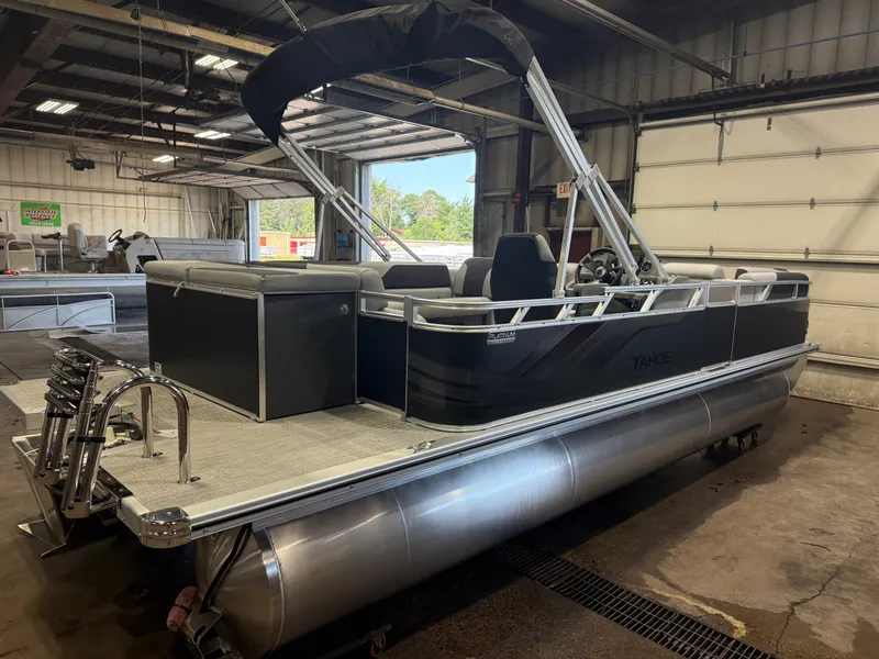 Slide: The Image of A modern pontoon boat with a black canopy and silver pontoons in a warehouse setting. - 41