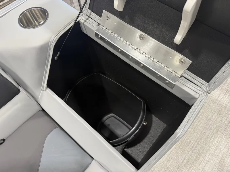 Slide: The Image of An open storage compartment with a black container and a cup holder beside it. - 24