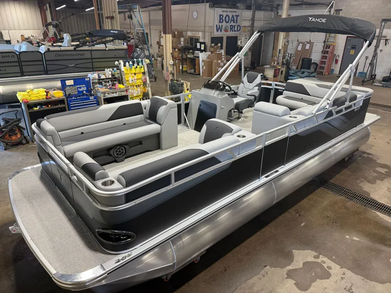 The Image of A modern pontoon boat with gray upholstery and a black bimini top in a workshop. - 1