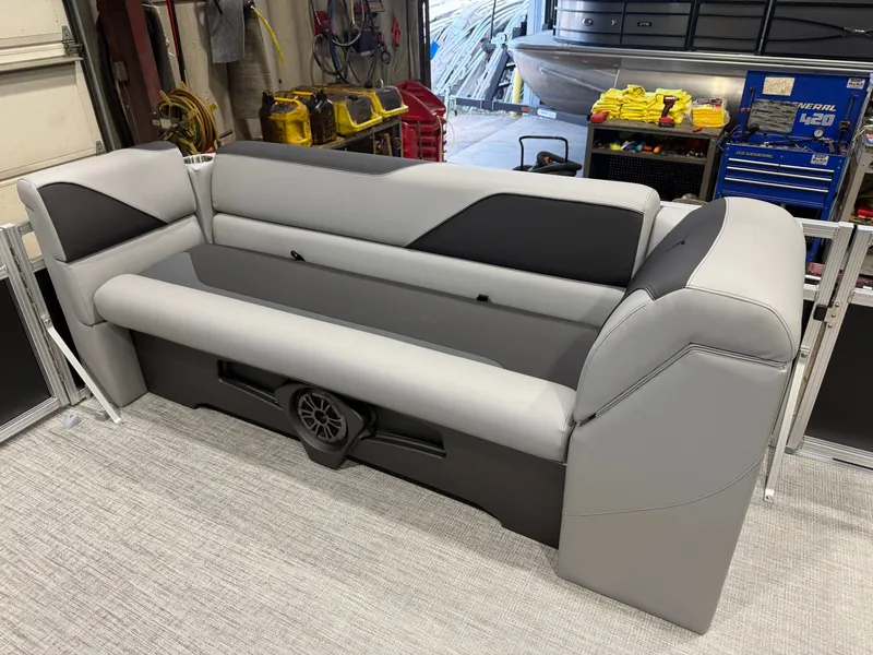 Slide: The Image of Gray and black boat seating in a workshop with tools in the background. - 28