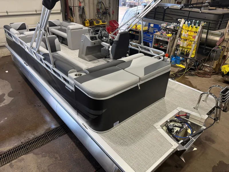 Slide: The Image of A modern pontoon boat with gray upholstery and a Honda 4-stroke engine in a workshop. - 43
