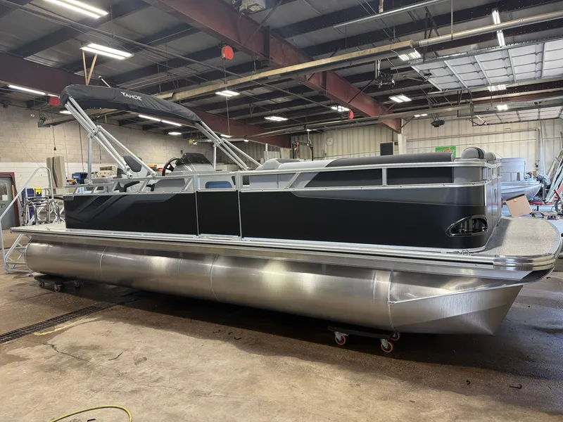 Slide: The Image of A modern pontoon boat with a black hull and silver details is in a warehouse. - 42