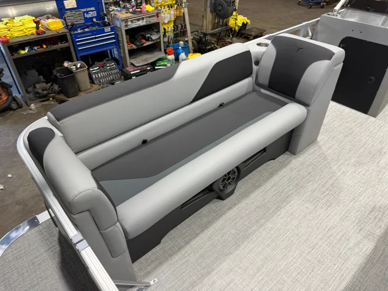 Slide: The Image of Gray and black bench seat on a boat with carpeted floor and workshop in the background. - 9