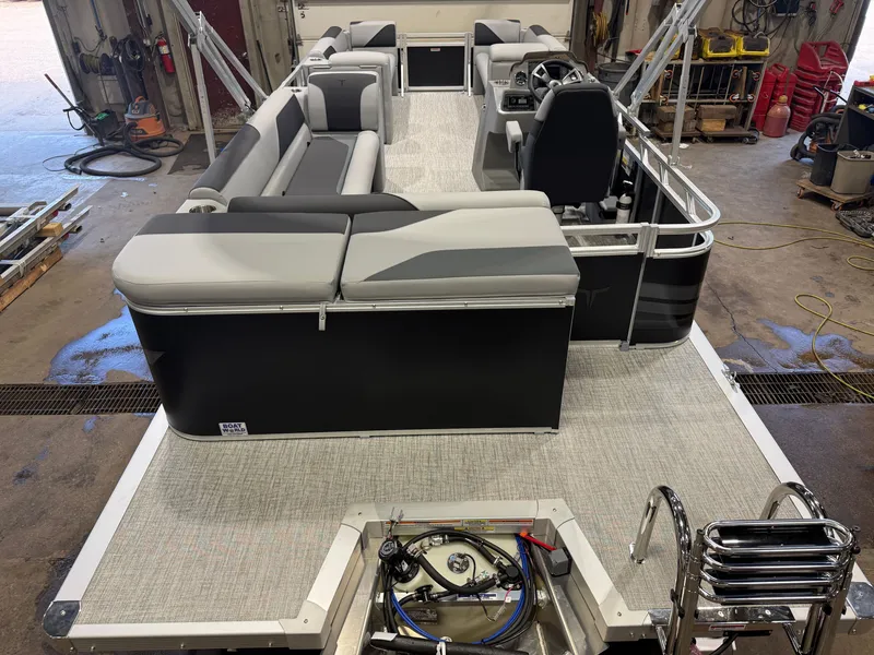Slide: The Image of The image shows a modern pontoon boat with gray and black seating, a helm, and a ladder. - 7
