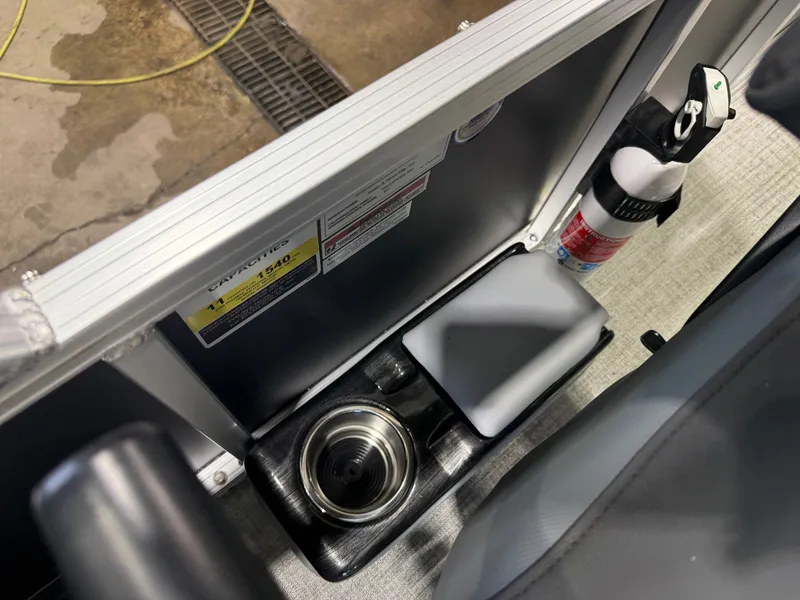Slide: The Image of Close-up of a boat area with a cup holder, fire extinguisher, and seat cushion. - 16
