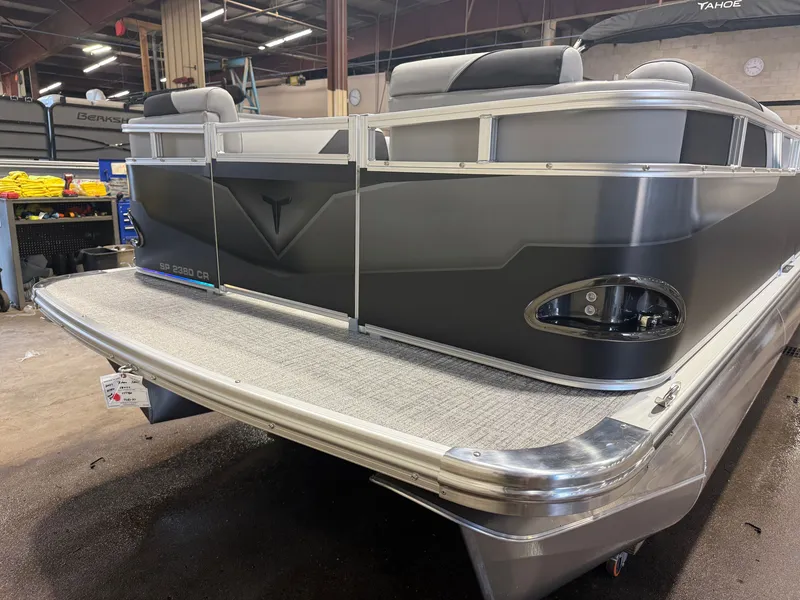 Slide: The Image of A modern pontoon boat's rear section in a warehouse, featuring gray upholstery and stainless steel railings. - 32