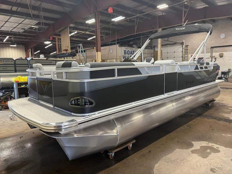 Slide: The Image of A modern pontoon boat with a gray hull and silver details in a warehouse setting. - 34