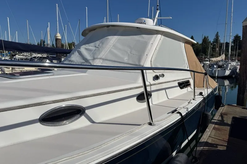 Slide: The Image of 2008 Back Cove 29 boat docked in a marina, featuring sleek design and white exterior. - 49