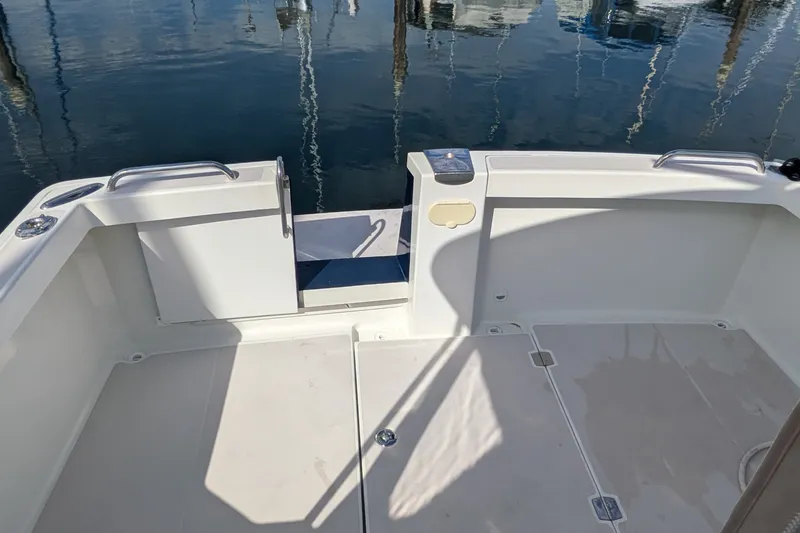 Slide: The Image of 2008 Back Cove 29 boat deck with open transom door, reflecting calm marina waters. - 22